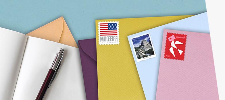 各种各样的彩色信封，上面有“爱”、“瀑布”和“你”.S. 旗一级邮件永久邮票.